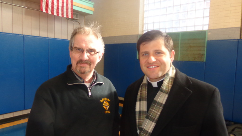 Knights of Columbus volunteer Robert Olson with Reverend Gerald Souza enjoying annual free throw event at the Walsh gym. 