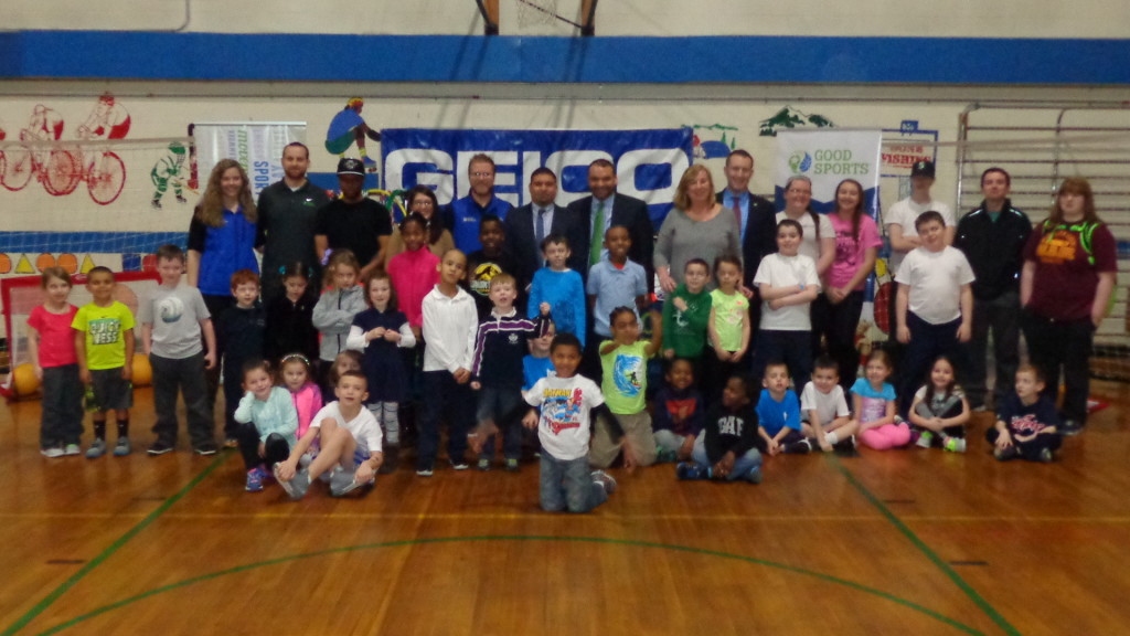 Representatives from GEICO, Good Sports and the City of Boston are pictured with Tynan Community Center gym members during the presentation of new equipment.