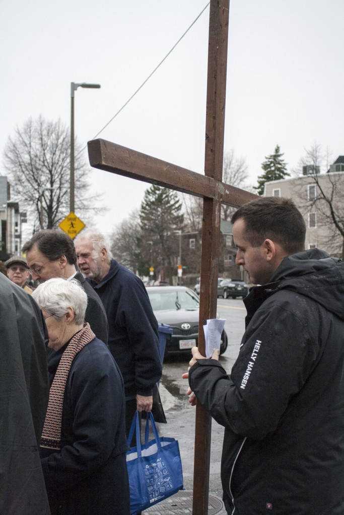 Phil Allison of St. Brigid Church holds the cross during the outdoor ecumenical Way of the Cross on Friday, March 25, 2016. (Photo by Susan Doucet)