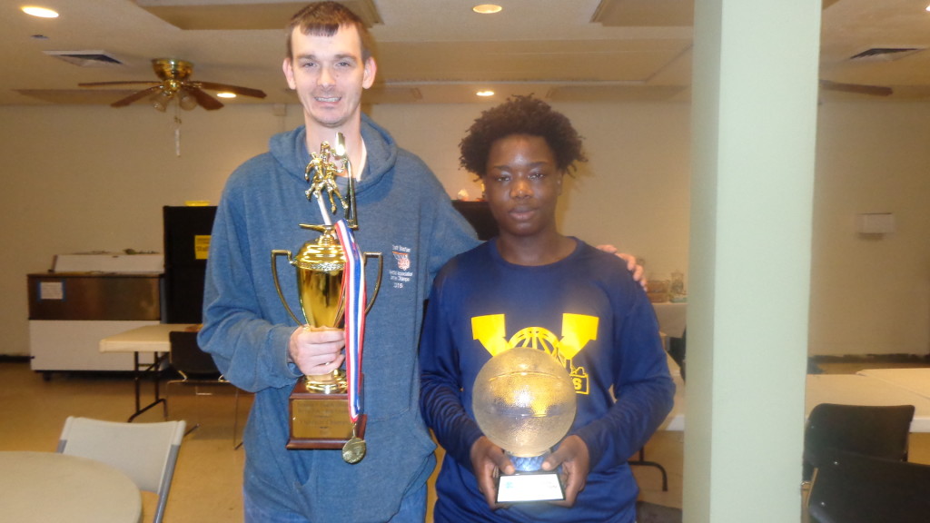 Pictured is Saint’s Vincent’s coach Billy Allen (left) holding the CYO Vicariate Tournament championship trophy, while his young assistant, AJ Mansaray (right) holds the CYO state tournament championship trophy.