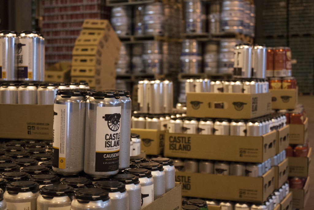 Cans of Castle Island Brewing Company's beer is stacked behind the tasting counter on Thursday, March 31, 2016. Causeway (as in Boston's Causeway Street) is a double IPA. (Photo by Susan Doucet)