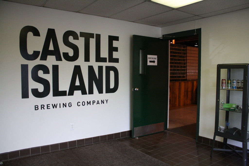 Castle Island Brewing Company in Norwood directs customers to its tasting area with a sign that reads, "beer this way." (Photo by Susan Doucet)