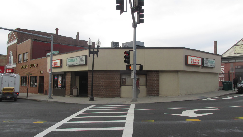 The existing Perkins Square corner (from left: Perkins Supply, Schubert’s, Dunkin’ Donuts, a small parking lot) where the proposed 480-482 West Broadway project will be built.