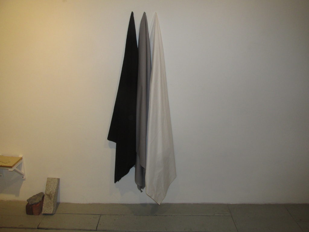 Simple, n’est-ce pas? Three hanging cloths – black, gray, white – form a work of art in Proof Gallery at 516 East Second St. (Photo by Rick Winterson)