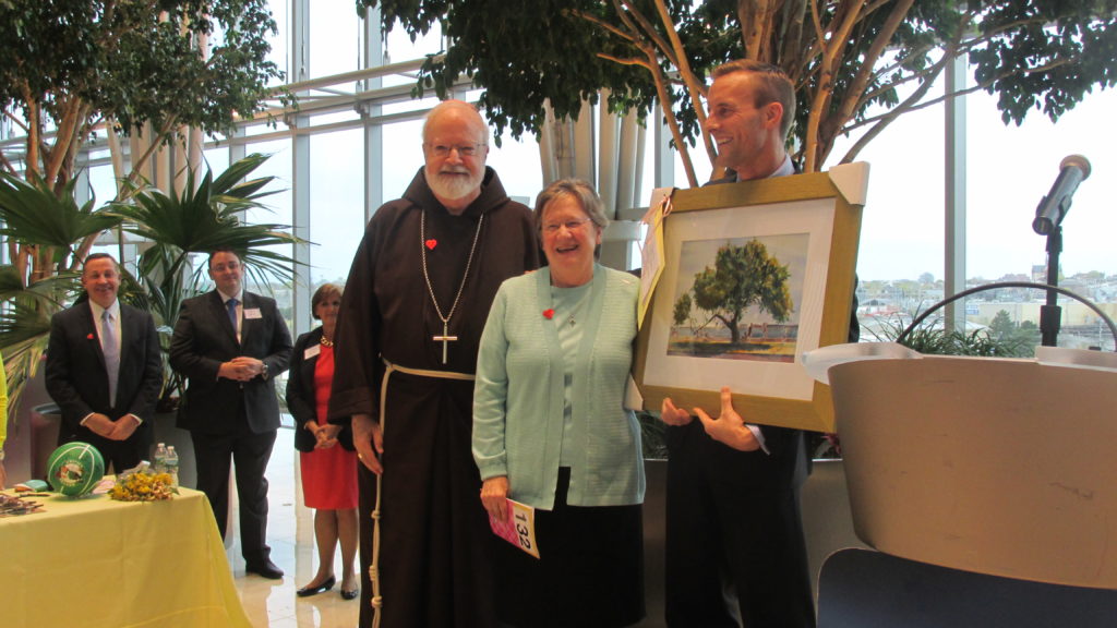 Sr. Maryadele Robinson receives a Dan McCole watercolor from Patrick Shaughnessy, as Cardinal Sean O’Malley looks on. (Photo by Rick Winterson)