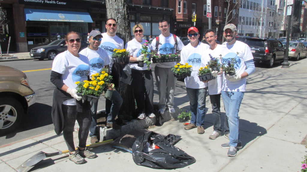 A Boston Shines group from the Saint Vincent Neighborhood Association fills the planters along West Broadway near F Street with colorful spring flowers. (Photo by Rick Winterson)