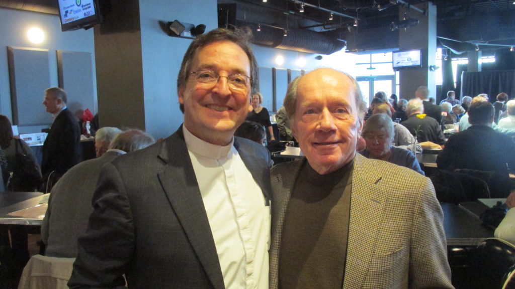 The Rev. Burns Stanfield has completed 25 years at the Fourth Church. He’s being congratulated by friend Wayne Johnson.