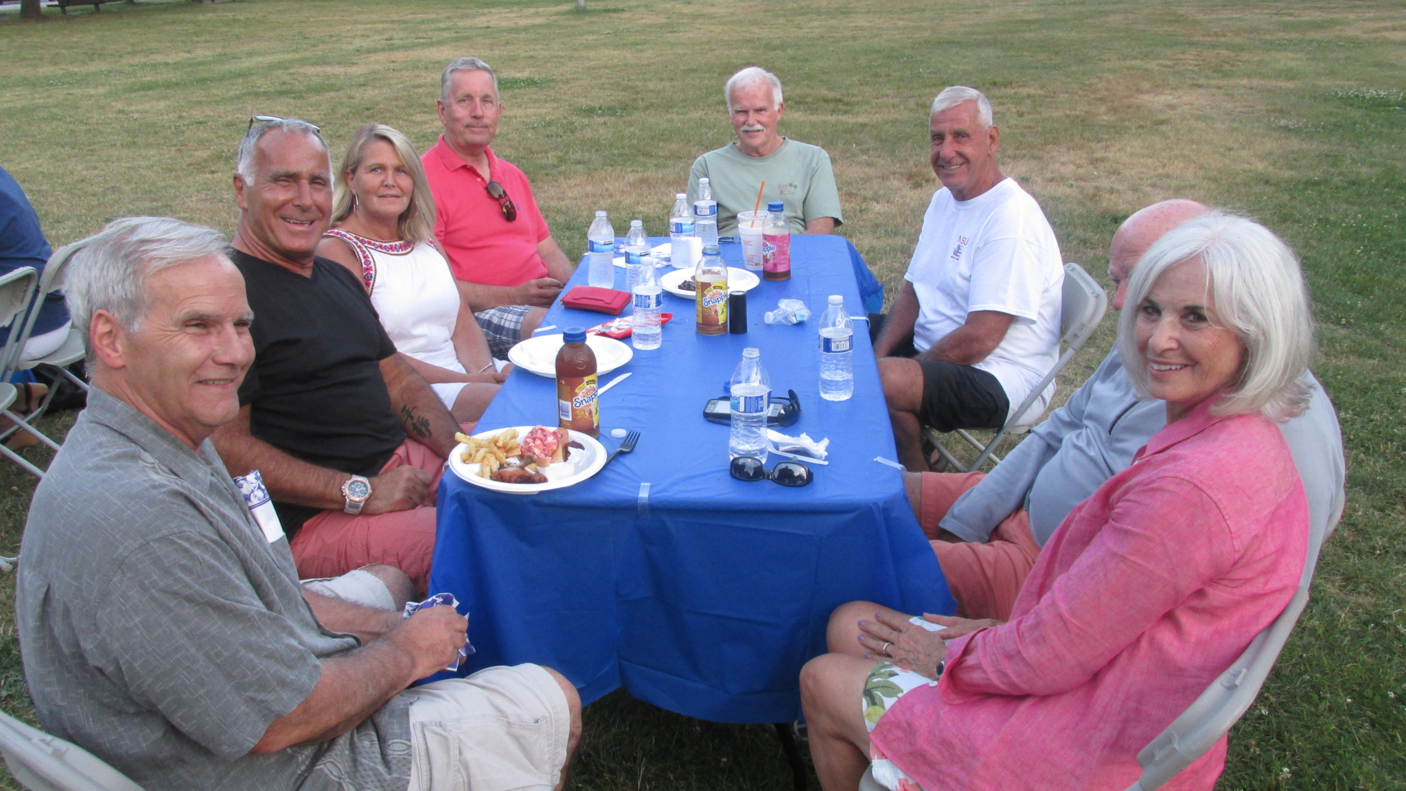 A table of revelers at Tom White’s “Open Hearts/Open Homes” cookout in Marine/Farragut Park.