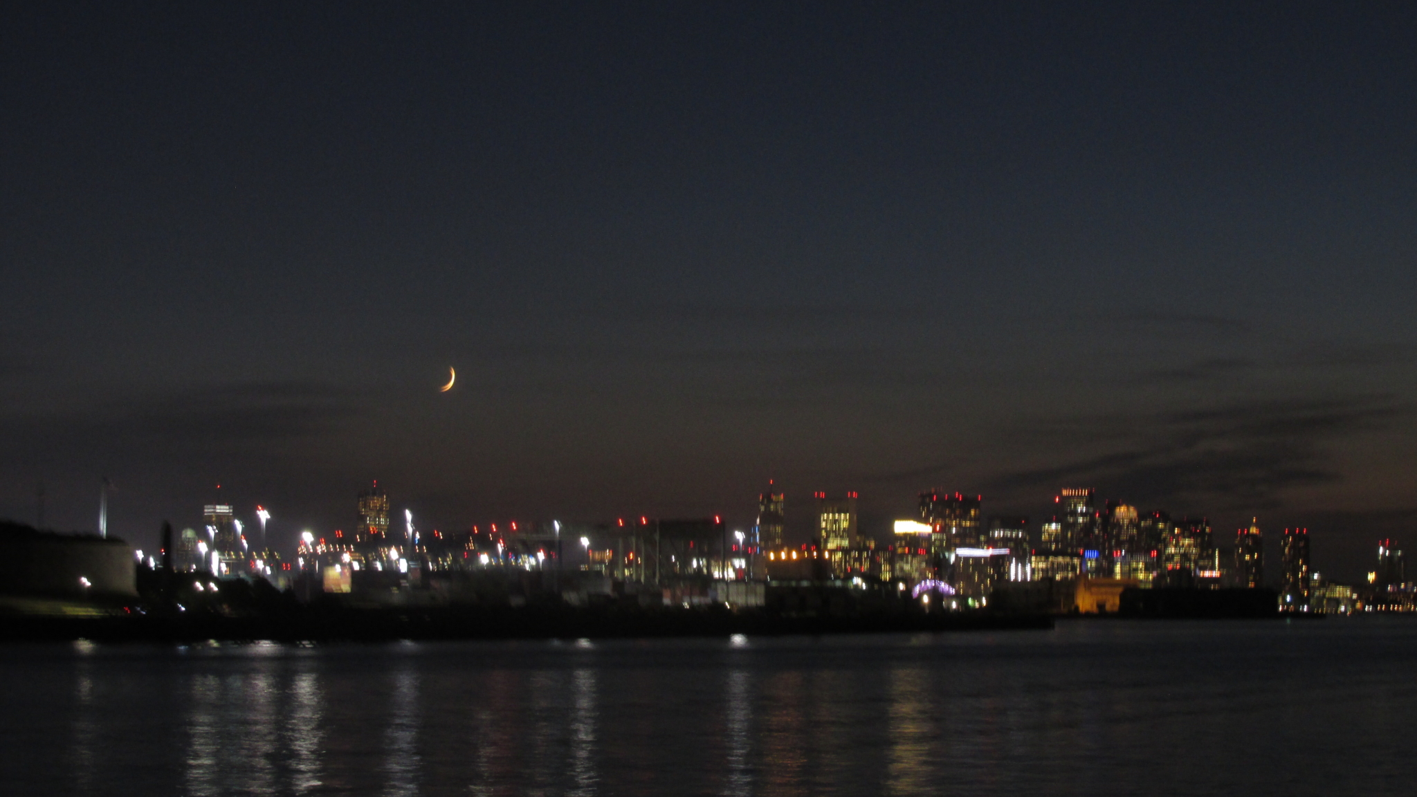 A portion of Boston’s skyline under a sliver of a crescent moon, as the Boys & Girls Club Cruise draws to a close.