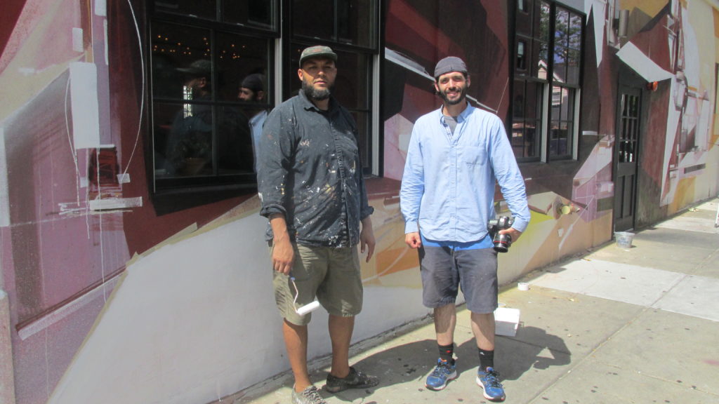 Augustine Kofie, with his friend and photographer Todd Mazer, on F Street in front of Kofie’s nearly finished mural/installation.
